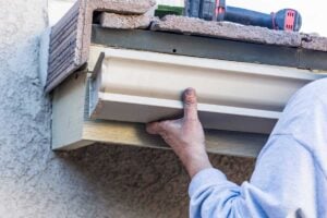 Blog 13 Technician inspecting gutter damage in Electric City SC for leaks and corrosion.