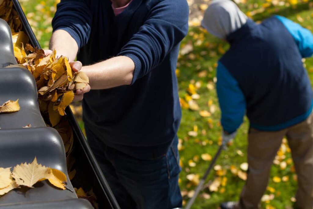 5 Essential Tips for Seamless Gutter Maintenance in Electric City SC 1 Technician performing seamless gutter maintenance in Electric City SC by cleaning debris from residential gutters.